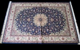 A Large Woven Silk Carpet Keshan rug with beige ground and blue border with traditional floral and