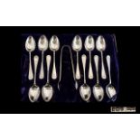 An Edwardian Period Set of 12 Sterling Silver Tea Spoons with Matching Pair of Sugar Nips.
