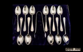 An Edwardian Period Set of 12 Sterling Silver Tea Spoons with Matching Pair of Sugar Nips.