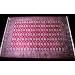 A Large Woven Silk Bokhara Carpet Ornate silk carpet with traditional lozenge and geometric repeat