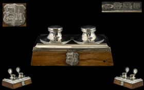 A Silver Arts And Crafts Dual Well Inkstand Of rectangular form, raised on golden oak base,