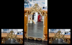 A Brass Framed Empire Style Bevelled Glass Mirror Rectangular form with shaped edge and broken