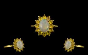 Opal and Yellow Sapphire Halo Ring, an oval cut cabochon opal of 1ct, framed by 1.