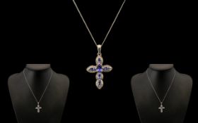 Tanzanite Cross Pendant, an oval cut tanzanite of .