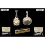 A Cased Vanity Set comprising a silver backed hand mirror, hair brush and clothes brush,