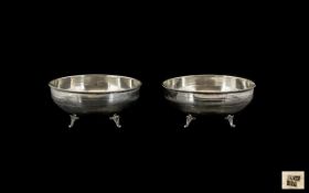 A Pair of Silver Bowls of plain form, with reeded decoration, raised on three shell feet.