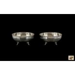 A Pair of Silver Bowls of plain form, with reeded decoration, raised on three shell feet.