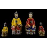 A Pair of Oriental Seated Figures depicting Emperor and Empress in bright coloured traditional