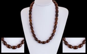 A Vintage Tortoiseshell Effect Graduating Bead Necklace comprising approx 30 barrel form beads,