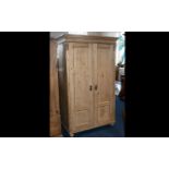 A Good Quality Solid Pine Two Door Wardrobe with the two panelled doors opening to reveal storage