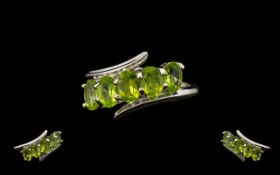 Peridot Crossover Set Ring, five oval cut peridots, set in a row, on a slight diagonal,