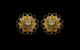 A Pair of 18ct Gold Stud Earrings of floral design. Set with a central white faceted stone. Fully