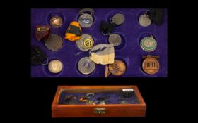 A Small Glazed Display Case containing a Collection of 12 Sporting Fobs awarded for athletics,