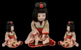 Vintage Japanese Ichimatsu Doll with original pink kimono with red sash, glass eyes and hair in bun.