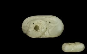 A Chinese Carved Mutton Fat Jade Pebble worked with an exotic feature. Approx 3 by 1.5 inches.