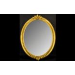 Large Oval Decorative Mirror with ornate fruit and leaf design to top and base of gilt frame.