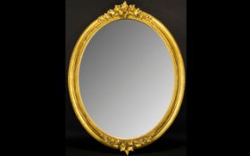 Large Oval Decorative Mirror with ornate fruit and leaf design to top and base of gilt frame.