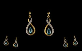 Sky Blue Topaz and Diamond Drop Earrings, each earring having a pear cut sky blue topaz,