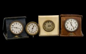Four Travelling Clocks early 20thC. All with white enamel dials and Arabic numerals, one with
