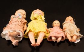 Four Various Plastic and Celluloid Baby Dolls, all in knitted clothes; sizes from 10.25 inches (26