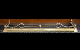 An Adjustable Brass Fender of Typical Form with a plinth base and scroll gallery. Length 57 inches