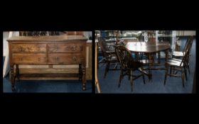 An Oak Rustic Sideboard with four drawers and turned supports with a cross stretcher to base.