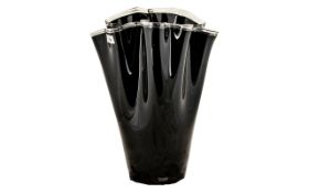 A Large Black Glass Handkerchief Vase finished in a high gloss sheen and measuring 21 inches in