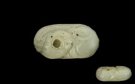 A Chinese Carved Mutton Fat Jade Pebble worked with an exotic feature. Approx 3 by 1.5 inches.