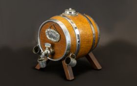 An Oak Scotch Barrel Dispenser with chrome banding.