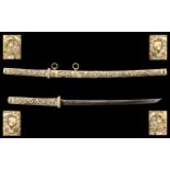 Japanese Samuri Sword with a carved bone handle and scabbard. Depicting Figures in various scenes,