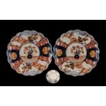 Japanese Imari Chargers - a pair with shaped edges of typical form and palette. 14'' diameter.