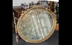 An Early 19thC Large Gesso Framed Wall Mirror with applied floral bow and garland pediment and