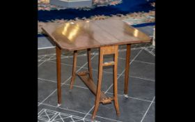 An Edwardian Mahogany Sutherland Drop Leaf Table with a satin wood edge and square splayed