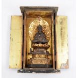 A small Buddhist shrine, enclosing a figure of Buddha