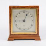An Elliott mantel clock with square dial and Roman numeral chapter ring in a square birds eye case