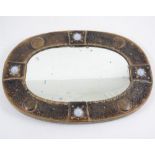 A small Arts and Crafts oval mirror, mounted with opalescent cabochons