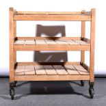 A vintage wooden three tier trolley with slatted shelves