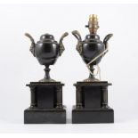 A pair of black marble urns, adapted as candlesticks