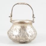 White metal cauldron-shape bowl with swing handle.