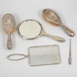 A collection of silver and silver backed dressing table items, hand mirror, brushes, an ebony brush