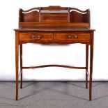 An Edwardian mahogany ladies' writing desk with inset black leather top, two drawers, raised