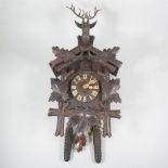 Black Forest cuckoo clock, the case surmounted with a carved stag head.