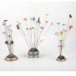 Three metal hat pin stands with hat pins - to include silver Charles Horner Art Nouveau style bead