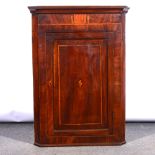 George IV mahogany and banded hanging corner cupboard.