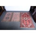 Zanjan rug, cruciform medallion on a red field, and two Hamadan rugs.