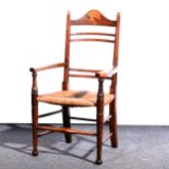An Arts and Crafts oak and inlaid rush seated ladder back chair, circa 1890.