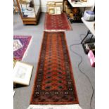 Bokhara rug, two rows of eight elephant foot guls on a red field, and a runner.