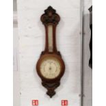 A carved oak aneroid banjo shape barometer,