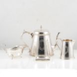 An Elkington & Co silver-plated three piece teaset, a silver cut edge design sauce boat on three