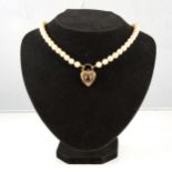 A cultured pearl necklace, forty-nine 7.8mm pearls fitted with a large 9 carat yellow gold padlock